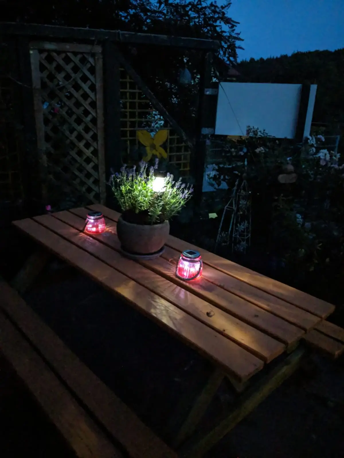 Gartentisch mit Windlichtern am Abend