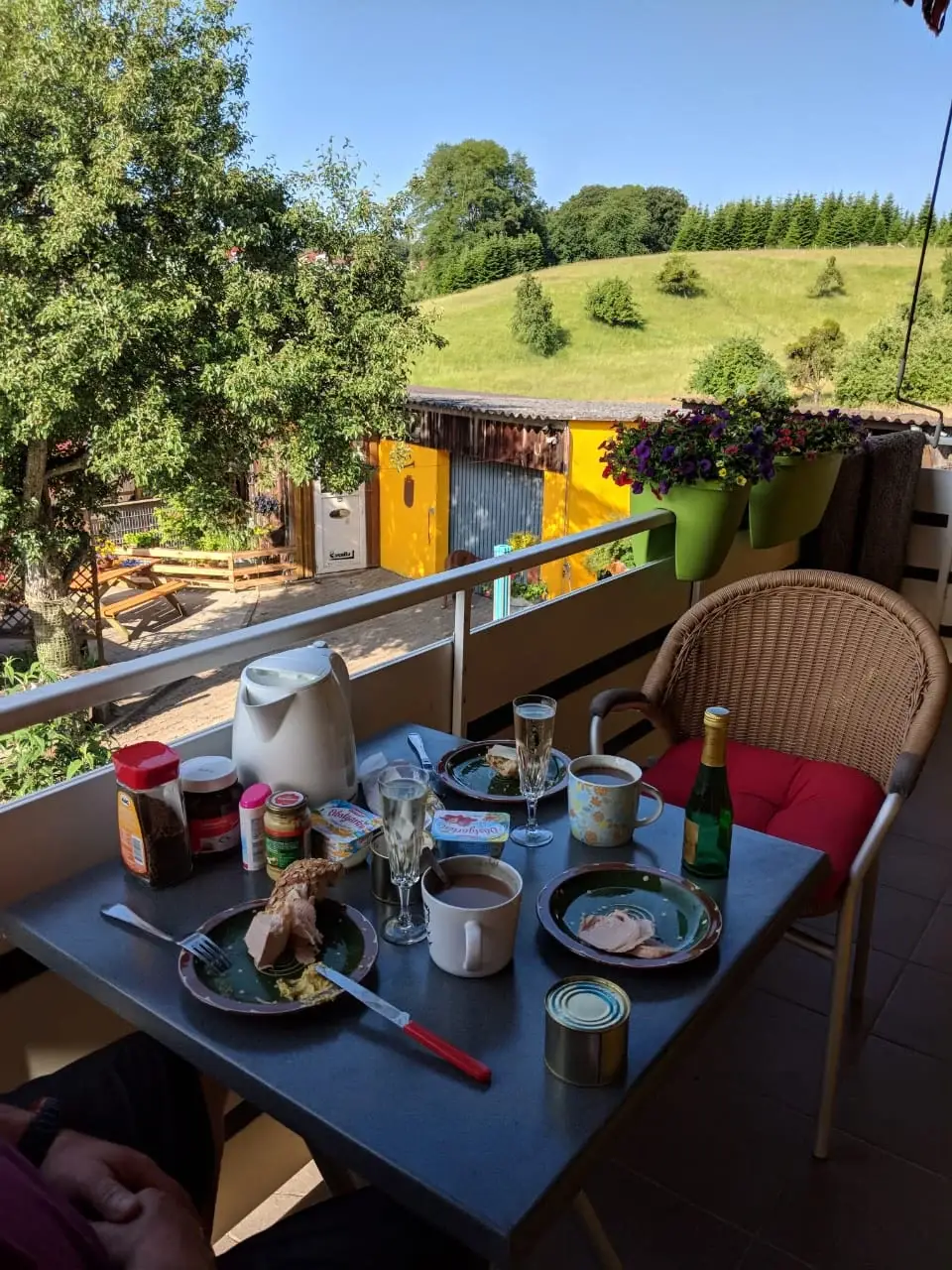 Gedeckter Frühstückstisch auf dem Balkon mit Blick auf die Hügel